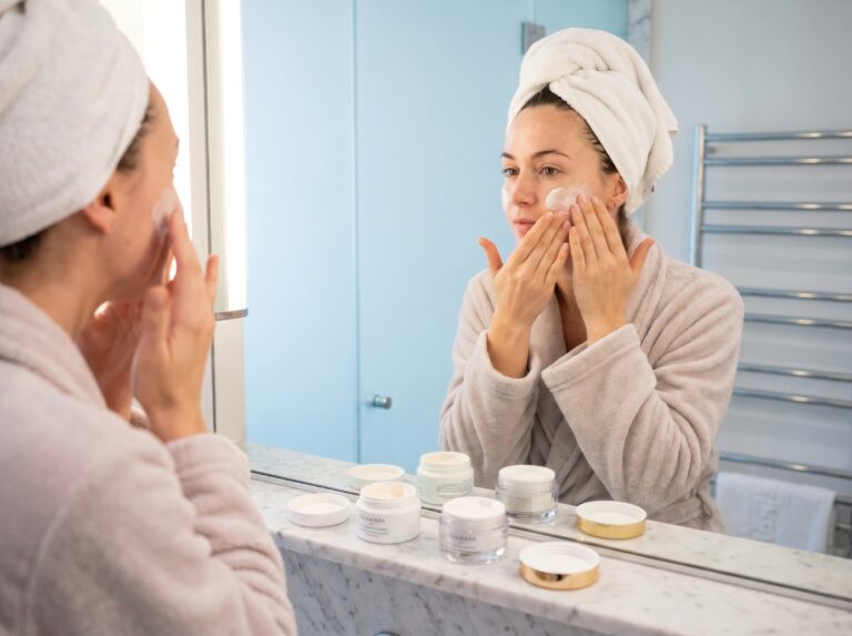 mulher aplicando creme facial no rosto